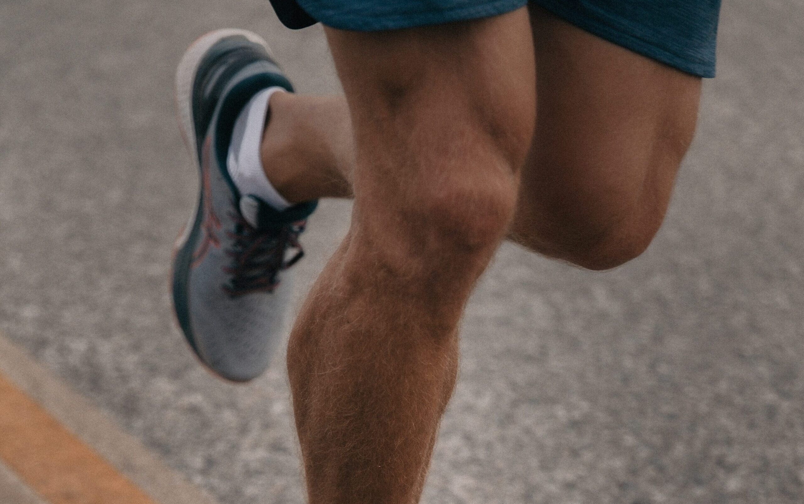 Close up photo of the knees of a man running